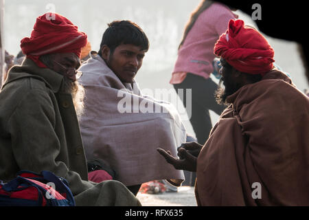 Uomini spirituali seduto al fiume Gange a freddo in inverno mattina in Haridwar, Uttarakhand, India Foto Stock