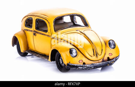 SWINDON, Regno Unito - 27 gennaio 2014: Retro distressted VW modello Beettle in giallo su sfondo bianco. Foto Stock