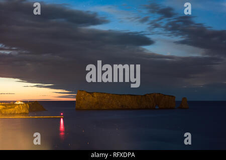 Famoso Rocher Perce rock in Gaspe Peninsula, Quebec, regione Gaspesie in Canada nella notte oscura del Cielo e nubi sunrise a Saint Lawrence golfo e rosso ref Foto Stock