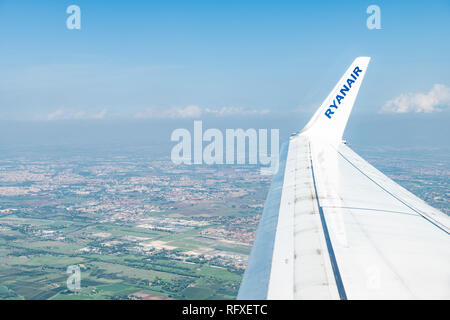 Ciampino, Italia - 6 Settembre 2018: Antenna ad alto angolo di visione su Ryanair ala di aeroplano da finestra sulla periferia di Roma case e inquinamento di haze sky Foto Stock