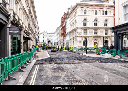 London, Regno Unito - 12 Settembre 2018: lavoratori edili con neon yellow uniformi lavora con il nero catrame e asfalto Bitume nel sito della città Foto Stock