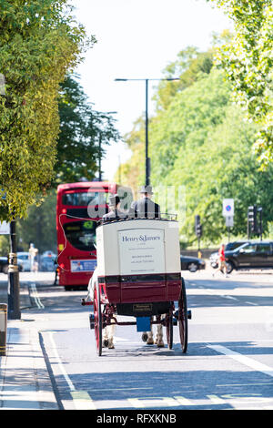 London, Regno Unito - 13 Settembre 2018: Street con tour a cavallo di trasporto tradizionali e le auto del traffico su strada da Kensington durante la giornata soleggiata vista verticale Foto Stock