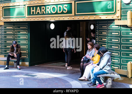 London, Regno Unito - 13 Settembre 2018: architettura di Knightsbridge con la gente seduta sul marciapiede da Harrods mall ingresso e firmare street day Foto Stock