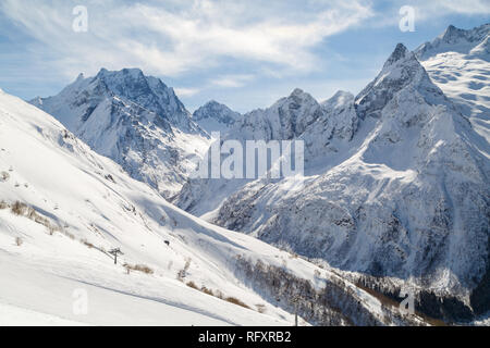 Tracciato di sci, una piccola sedia ski-lift contro lo sfondo delle montagne del Caucaso gamma vicino alla città di Dombai, Russia Foto Stock