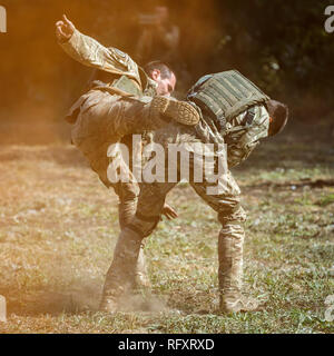 Festival storici Sambek altezze. Soldati di special purpose distacco dimostrare il combattimento a mani nude in fumo arancione Foto Stock