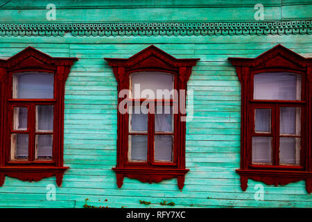 Windows in una vecchia casa in legno di close-up. Dettagli architettonici. Foto Stock