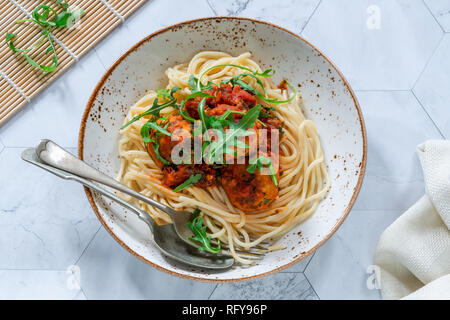 Spaghetti al tonno sfere in piccante salsa di pomodoro e rucola Foto Stock