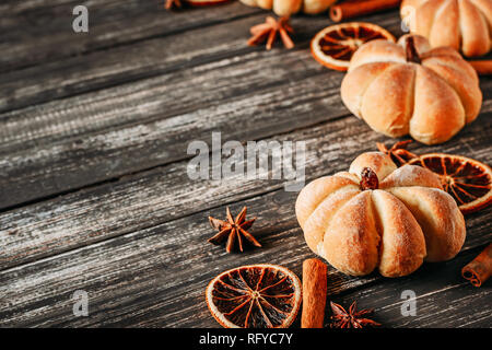 Torte fatte in casa a forma di zucca e arance essiccato sul legno scuro backgroundm vista superiore con spazio di copia Foto Stock