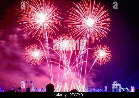 La folla a guardare i fuochi d'artificio e celebrare la città fondata. Bella coloratissimi fuochi d'artificio nell'urbano per la celebrazione nella notte oscura dello sfondo. Rosso Foto Stock
