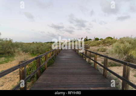 Passerella in legno e duna costiera la vegetazione a Beach, Praia Manta Rota, Algarve, Portogallo. Foto Stock