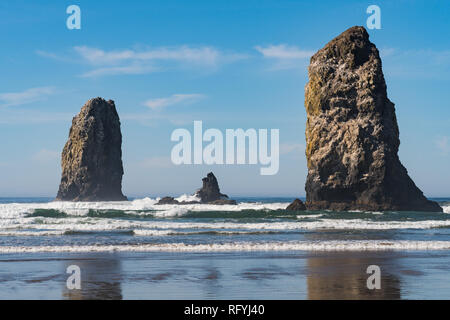 Onde che si infrangono sulle rocce verticali sporgenti in Cannon Beach, Oregon, Stati Uniti d'America. Foto Stock