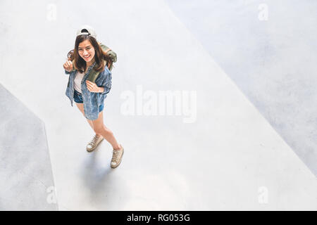 Giovane bella asiatica zaino traveler, carino donna che indossa hat guardando verso l'alto e sorriso, vista dall'alto con copia spazio. Viaggio viaggio lifestyle, world travel Foto Stock