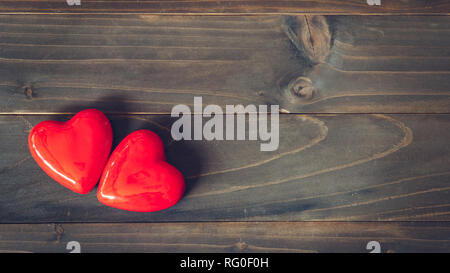 Due cuore rosso sul tavolo in legno con sfondo spazio copia Foto Stock