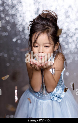 Splendido piccolo bambino ragazza in argento e vestito blu con i confetti Foto Stock