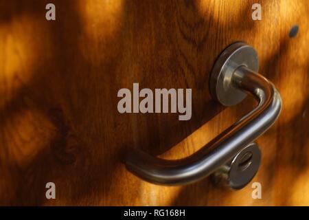 Brown porta in legno con maniglia cromata. Round raggi solari Foto Stock