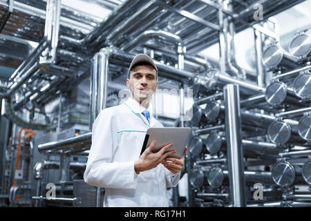 Il Tecnologo con una compressa nelle sue mani presso il caseificio Foto Stock