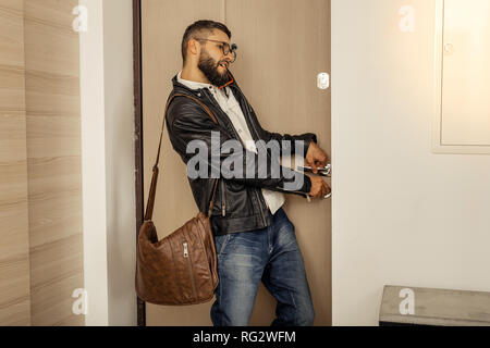 Bello alto a pelo corto uomo barbuto con un sacchetto della chiusura dello sportello Foto Stock