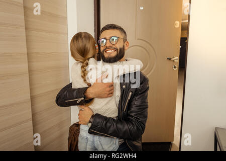 Bello dai capelli scuri uomo barbuto in occhiali una buona sensazione Foto Stock