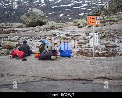 ODA, Norvegia-Giugno 22, 2017: gruppo di turisti zaino seduto sulla cima della montagna sul modo per Trolltunga Foto Stock