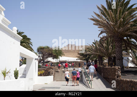 Turista che visita la città di Teguise con il castello del XVI secolo, Castillo de Santa Barbara sulla cima della montagna, Isole Canarie, Lanzarote, Spagna Foto Stock