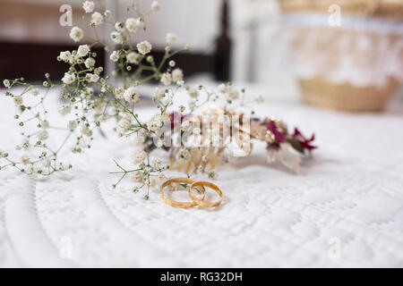 Gli anelli di fidanzamento per un matrimonio con fiori dietro Foto Stock