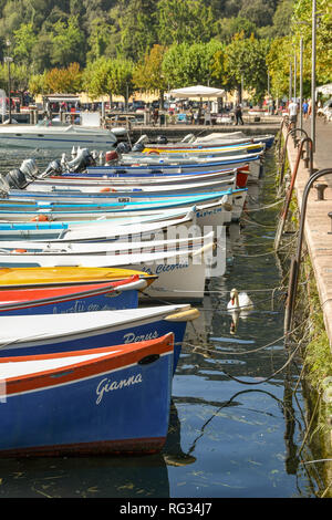 Il LAGO DI GARDA, Italia - Settembre 2018: piccole barche da pesca allineate nel porto della città del Garda sul Lago di Garda. Foto Stock