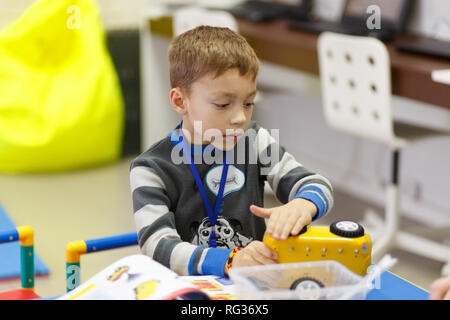 Il ragazzo raccoglie un modello di un radio-controllato auto da blocchi di una centralina elettronica-progettista meccanico presso la scuola di tecnologie digitali. Il suo wor Foto Stock