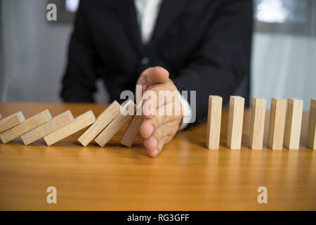 Imprenditore si ferma mano domino capovolta continua nel senso che ostacolavano il fallimento aziendale. Stop Over questo fallimento aziendale concetto. Foto Stock