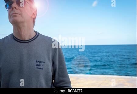 Close up di un uomo rilassato indossare una felpa con lo slogan "respirare, pensare, sogno". Foto Stock