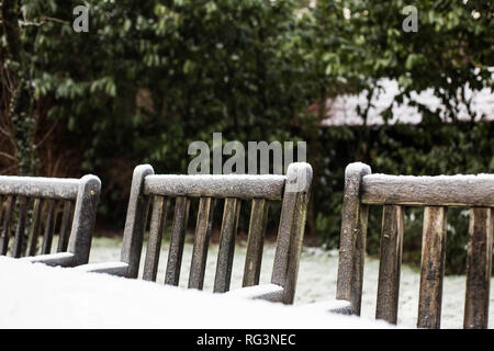 Accogliente in legno Sedie da giardino coperto di neve in un giardino nel cortile. Foto Stock