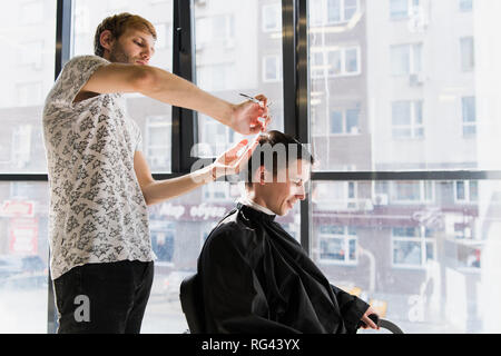 Uomini acconciature e taglio di capelli in un negozio di barbiere o parrucchiere Foto Stock