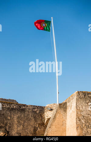 Bandiera portoghese sulla sommità del castello medievale del villaggio portoghese Castro Marim, Algarve, Portogallo. Foto Stock