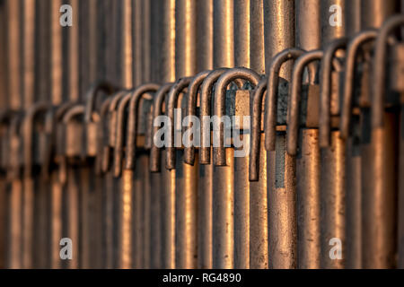 Barre di metallo in una fila al tramonto Foto Stock