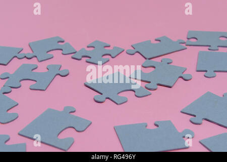 Puzzle di carta su un sfondo rosa Foto Stock