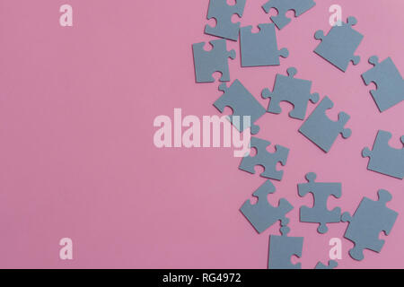 Puzzle di carta su un sfondo rosa Foto Stock