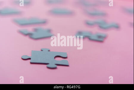 Puzzle di carta su un sfondo rosa Foto Stock