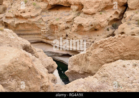 I turisti di prendere un bagno con acqua verde smeraldo sul wadi FUSC. Questa valle è una delle più incredibili in Oman Foto Stock