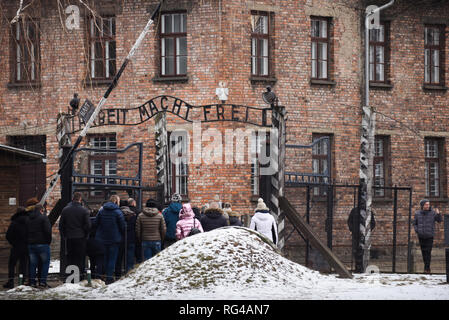 I visitatori sono visto che attraversa la famosa Porta del camp durante 74anniversario della liberazione di Auschwitz e l'olocausto Giorno del Ricordo. Il tedesco più grande campo di lavoro e sterminio nazista KL Auschwitz-Birkenau fu liberata da parte dell'Armata Rossa il 27 gennaio 1945. Foto Stock