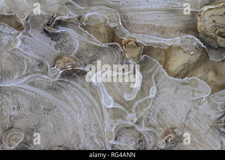 Macro di un gelido pozza o modelli di ghiaccio su una stradina di ghiaia in inverno in Italia Foto Stock