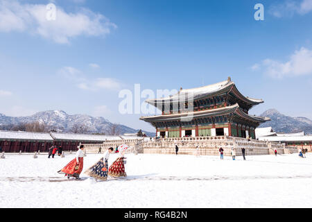 Il palazzo Gyeongbokgung in inverno e le ragazze in abiti Hanbok. Foto Stock