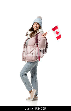 Felice studentessa in abbigliamento invernale con la bandiera canadese isolato su bianco, studiare all'estero concetto Foto Stock