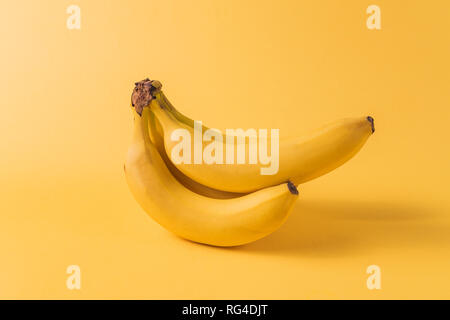 Il minimalismo creativi concetto. Concetto di imprevisti. Appartamento vista laici di banana frutto pattern su sfondo giallo. Foto Stock