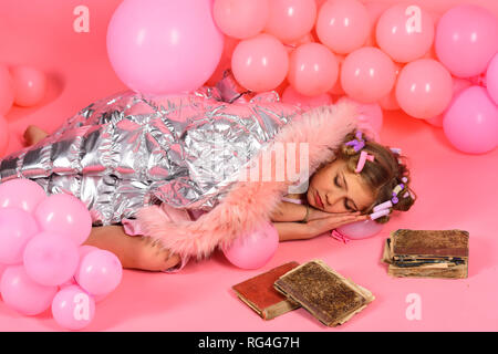 Poco un anno vecchia ragazza a dormire di libri antichi Foto Stock