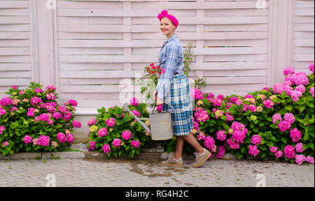 Fiori di serra. hydrangea. La primavera e l'estate. donna felice giardiniere con fiori. La cura dei fiori e irrigazione. suoli e fertilizzanti. donna cura di Foto Stock