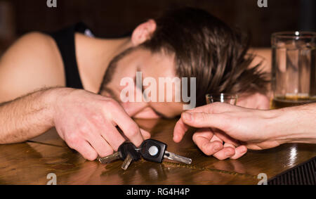 Segnalazione di incidente d'auto. Uomo alcolica con chiavi auto dormire al banco bar. L'uomo dopo aver bevuto alcool e birra nei pub. L'alcol addict con Foto Stock