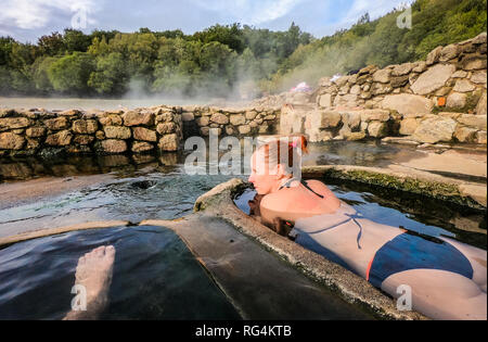 La donna si rilassa e gode naturali di acqua calda acqua termale terme romane. Piscine e vasche da bagno con acqua calda, fumatori acqua termale e primavera calda di Aquis Querquen Foto Stock