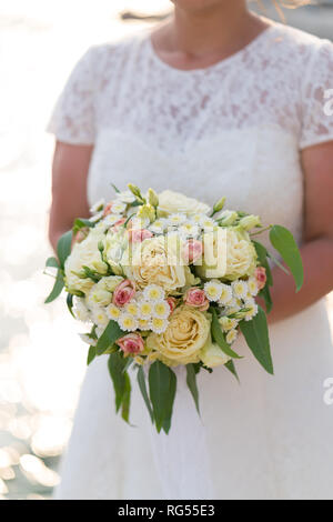 La sposa è in possesso di una rosa e beige wedding bouquet di fiori freschi e eucalipto Foto Stock