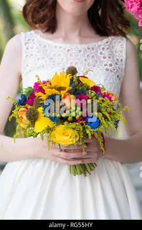 Sposa tenendo un coloratissimo matrimonio bouquet di fiori freschi Foto Stock