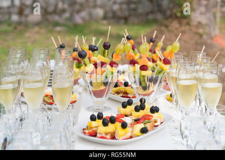 Bicchieri di champagne e vari snack per il consumo dopo la cerimonia di nozze Foto Stock