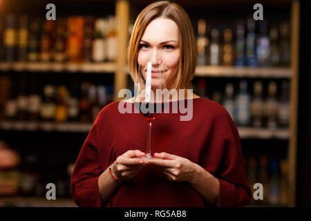 Immagine di donna con vetro in mani al negozio con il vino Foto Stock